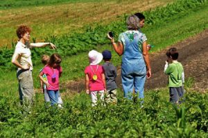 Adulti e bambini in visita presso una fattoria didattica